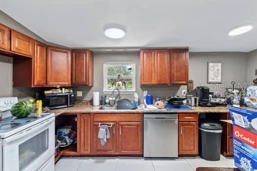 kitchen with light tile patterned flooring, sink, and stainless steel appliances