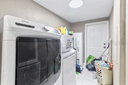 washroom with washer and dryer and light tile patterned floors