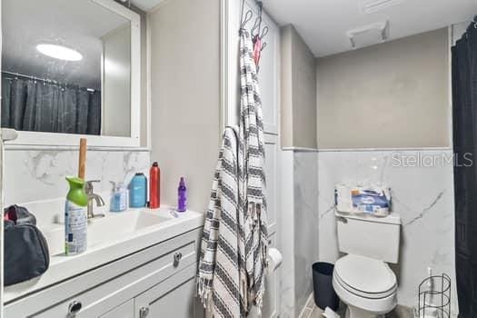 bathroom with a shower with curtain, vanity, and toilet