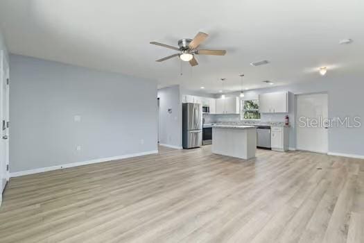 unfurnished living room featuring ceiling fan and light hardwood / wood-style flooring