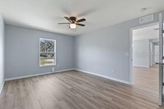 empty room featuring ceiling fan and light hardwood / wood-style floors