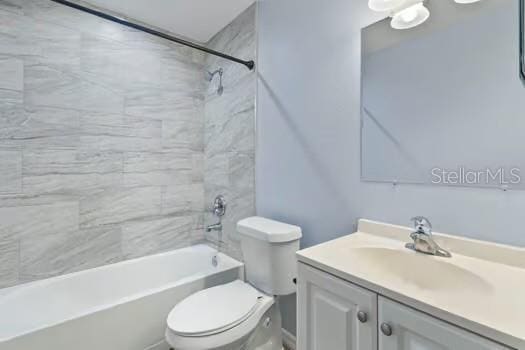 full bathroom featuring vanity, toilet, and tiled shower / bath