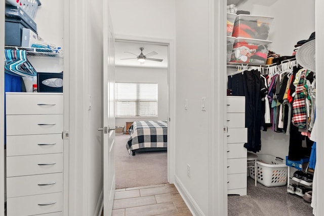 spacious closet featuring light colored carpet and ceiling fan