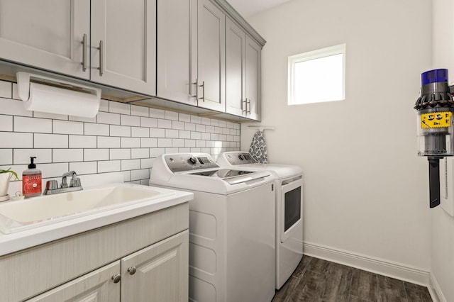 washroom featuring sink, cabinets, washer and clothes dryer, and dark hardwood / wood-style floors