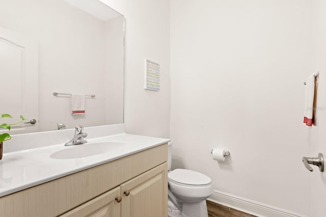 bathroom with toilet, wood-type flooring, and vanity