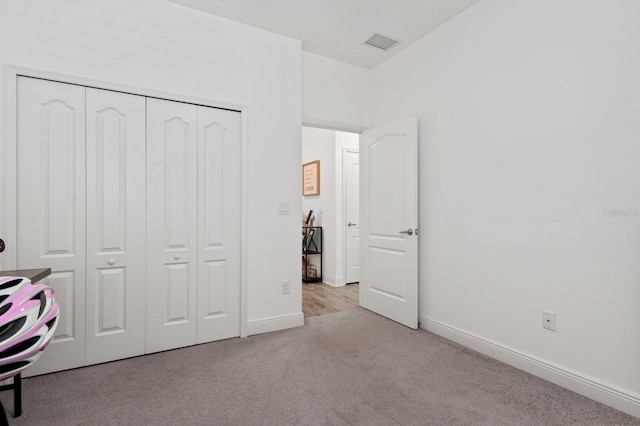 unfurnished bedroom featuring a closet and light carpet