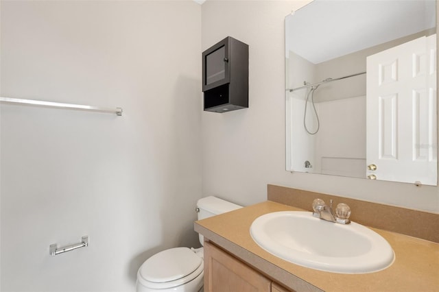 bathroom featuring a shower, vanity, and toilet