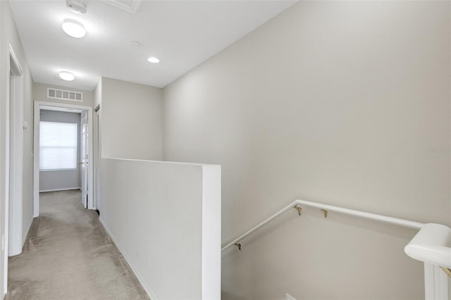 hallway featuring light colored carpet