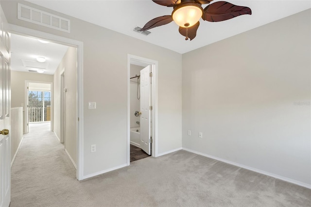 unfurnished bedroom featuring connected bathroom, light colored carpet, and ceiling fan