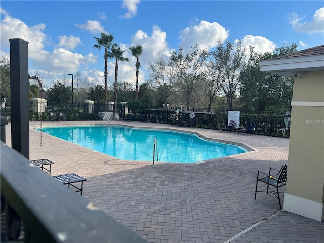 community pool featuring fence and a patio