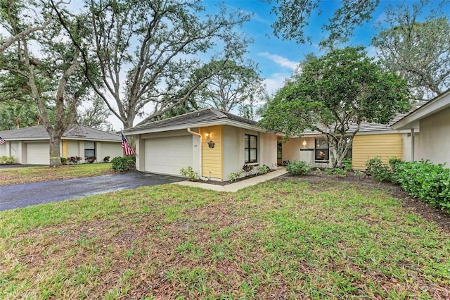 ranch-style home featuring a garage and a front lawn