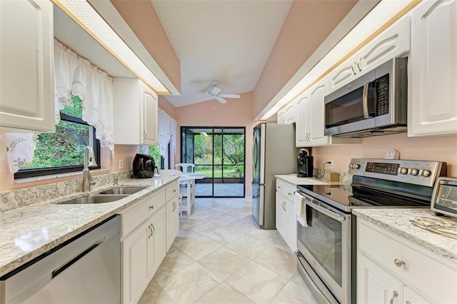 kitchen with a wealth of natural light, white cabinetry, sink, and appliances with stainless steel finishes