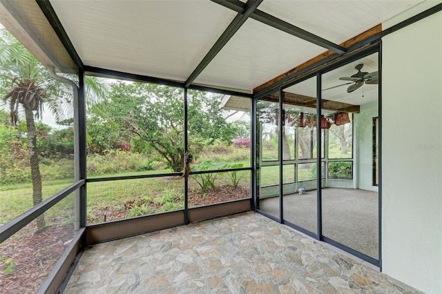 unfurnished sunroom featuring ceiling fan