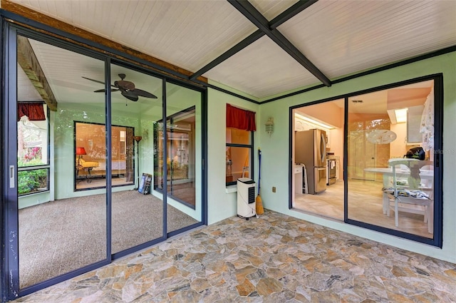 unfurnished sunroom featuring heating unit and ceiling fan