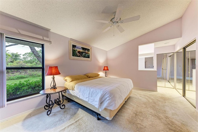 carpeted bedroom with a textured ceiling, ceiling fan, and vaulted ceiling