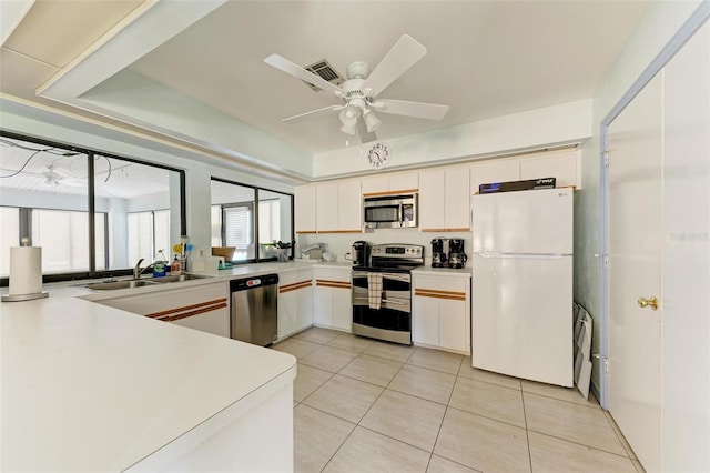 kitchen featuring ceiling fan, sink, light tile patterned flooring, white cabinets, and appliances with stainless steel finishes