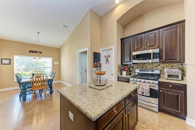 kitchen featuring stainless steel appliances, decorative backsplash, a kitchen island, an inviting chandelier, and decorative light fixtures