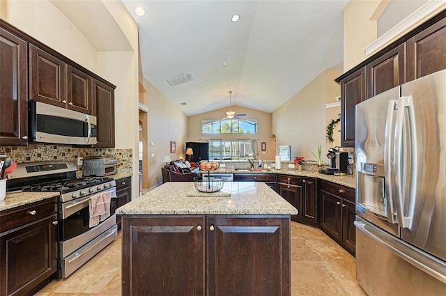 kitchen featuring stainless steel appliances, a center island, kitchen peninsula, decorative backsplash, and lofted ceiling