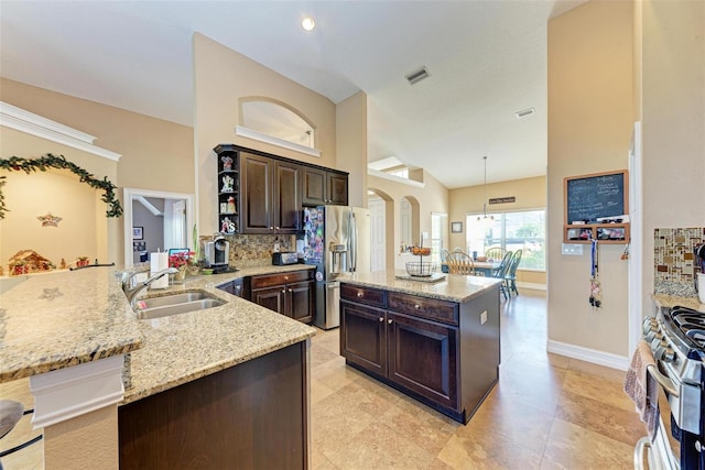 kitchen featuring sink, decorative light fixtures, appliances with stainless steel finishes, and dark brown cabinetry