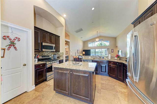 kitchen with a center island, lofted ceiling, ceiling fan, kitchen peninsula, and appliances with stainless steel finishes