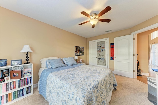 carpeted bedroom with ceiling fan and a closet