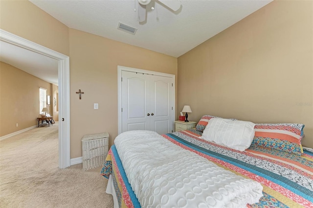 carpeted bedroom with ceiling fan and a closet