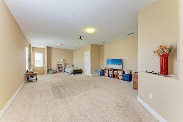 sitting room with light colored carpet and a textured ceiling