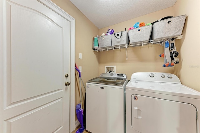 laundry area featuring washer and clothes dryer and a textured ceiling