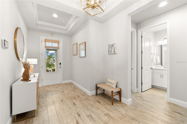 foyer entrance featuring a tray ceiling and a notable chandelier