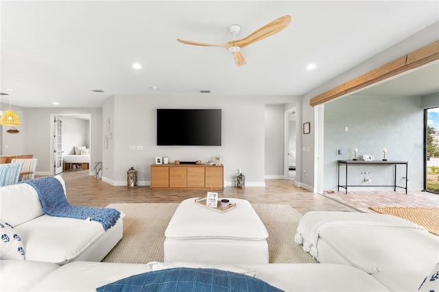 living room featuring ceiling fan and light hardwood / wood-style floors