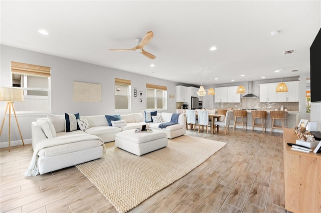 living room with light hardwood / wood-style floors and ceiling fan