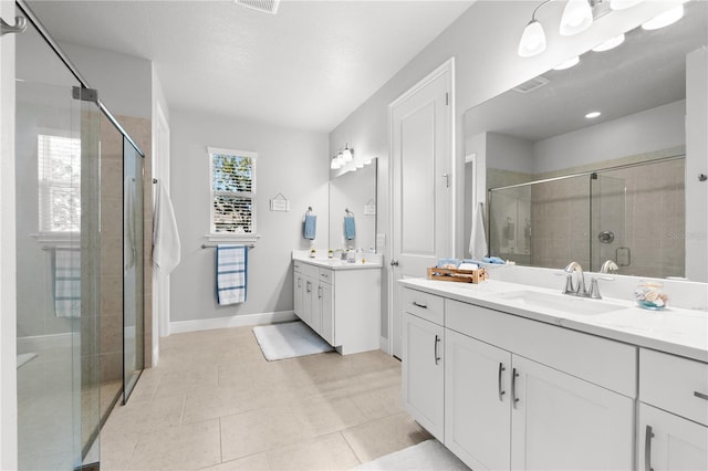 bathroom featuring tile patterned flooring, vanity, and a shower with shower door