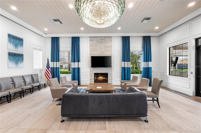 living room featuring a tile fireplace, an inviting chandelier, plenty of natural light, and wood ceiling