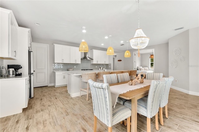 dining room featuring a notable chandelier, light hardwood / wood-style floors, and sink