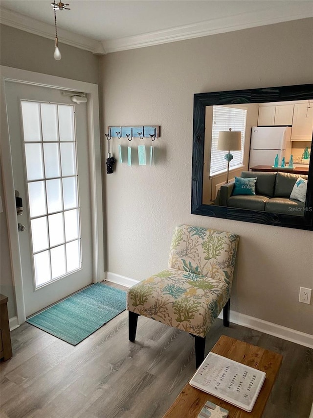 living area featuring crown molding and hardwood / wood-style flooring