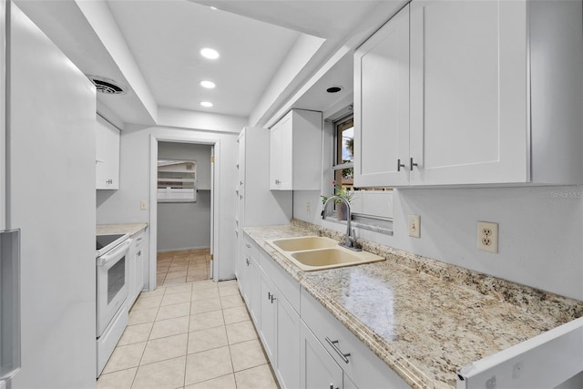 kitchen with sink, white electric stove, white cabinets, and light tile patterned floors