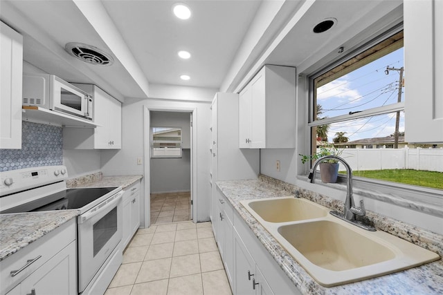 kitchen with sink, white appliances, white cabinetry, and light tile patterned flooring