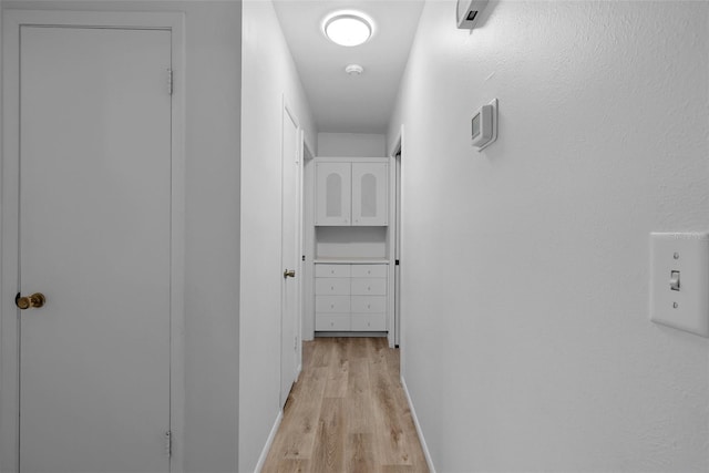 hallway with light hardwood / wood-style floors