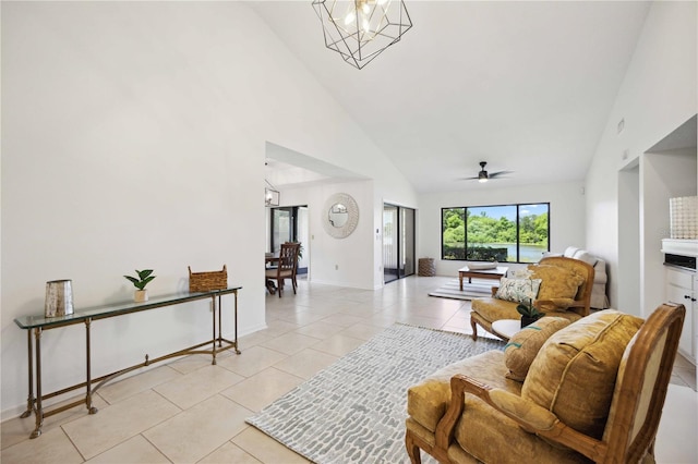 living room featuring ceiling fan with notable chandelier, high vaulted ceiling, and light tile patterned flooring