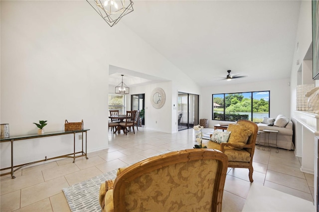 living room with high vaulted ceiling, ceiling fan with notable chandelier, and light tile patterned floors