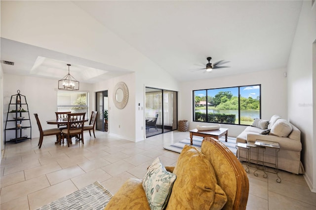 tiled living room with vaulted ceiling and ceiling fan with notable chandelier