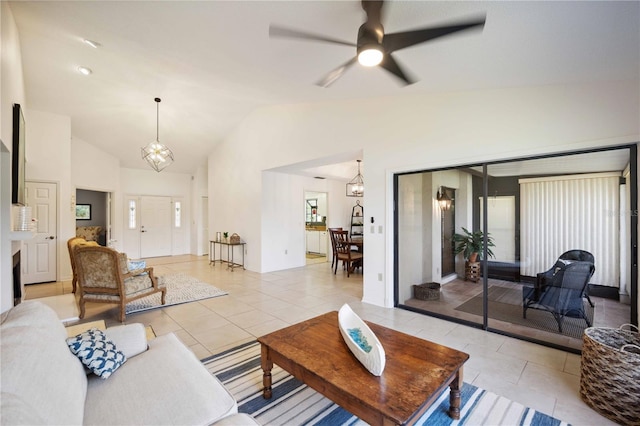 tiled living room featuring ceiling fan with notable chandelier and high vaulted ceiling