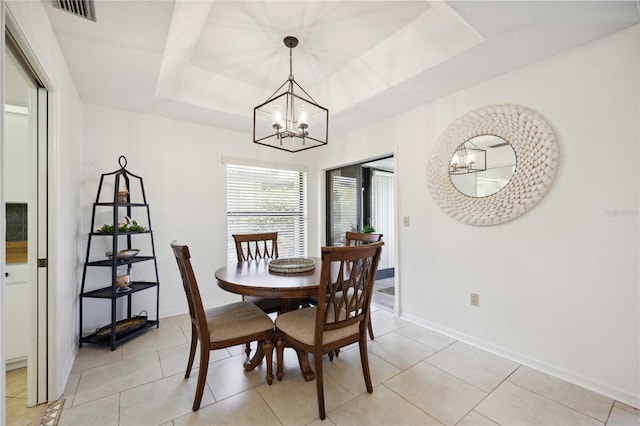 tiled dining room with a raised ceiling and a notable chandelier