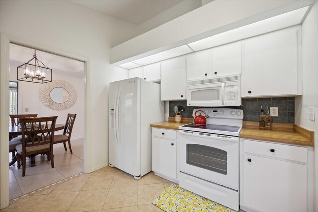 kitchen with white appliances, light tile patterned floors, white cabinetry, and butcher block counters