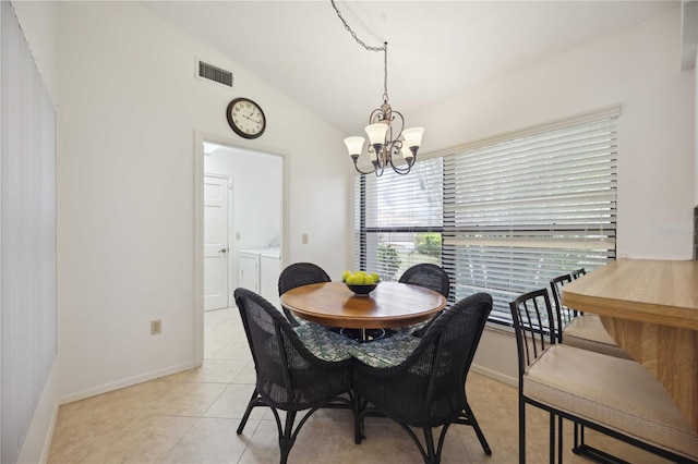 tiled dining space featuring separate washer and dryer, lofted ceiling, and a chandelier