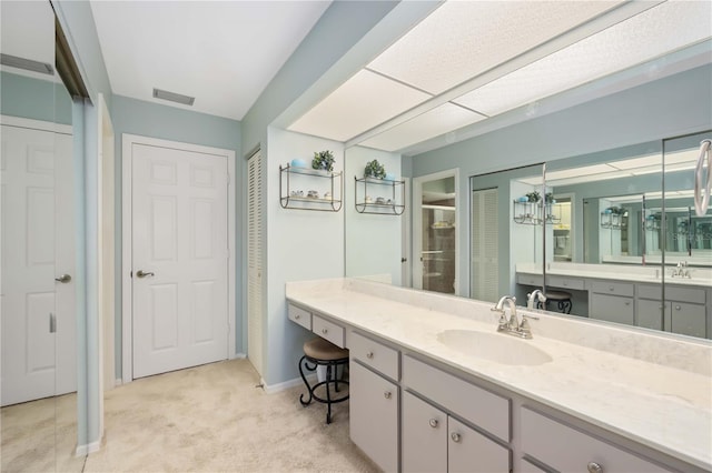 bathroom featuring walk in shower and vanity