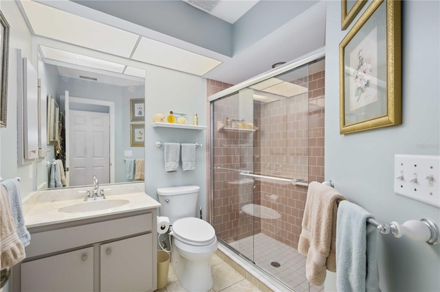 bathroom featuring a shower with door, tile patterned floors, vanity, and toilet