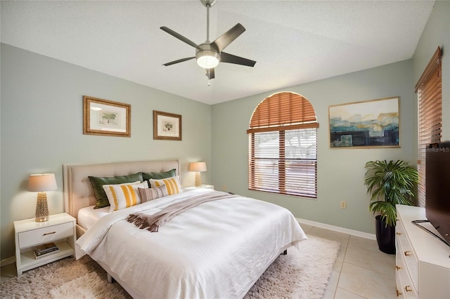 bedroom featuring a textured ceiling, light tile patterned flooring, and ceiling fan