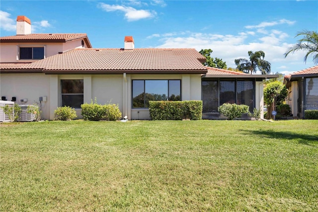 back of property featuring central AC and a lawn