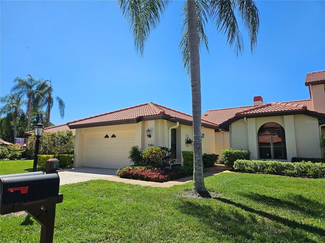 mediterranean / spanish-style house with a front yard and a garage